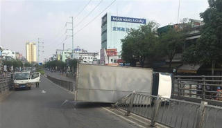 TP HCM: Xe tải lật ngang trên cầu vượt, hai người bị thương nặng