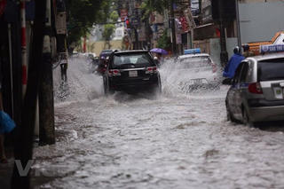 Hình ảnh người Hà Nội chật vật di chuyển trong cơn mưa lớn