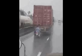 [VIDEO] Điều khiển xe máy chạy bám đuôi xe công-ten-nơ để... trú mưa