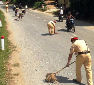 CSGT giúp dân nhặt tôm, quét đá dăm trên đường