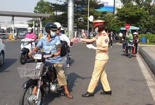 Nữ cảnh sát giao thông phát hàng ngàn khẩu trang miễn phí ở sân bay
