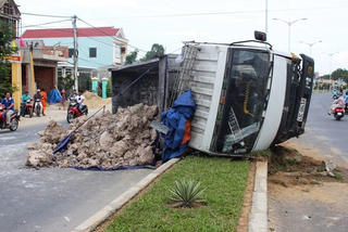 Xe tải tông vào dải phân cách lật nghiêng giữa đường