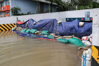 Ảnh hưởng bão số 10, đường phố Hà Nội ngập úng, người dân dùng bao cát chắn cửa