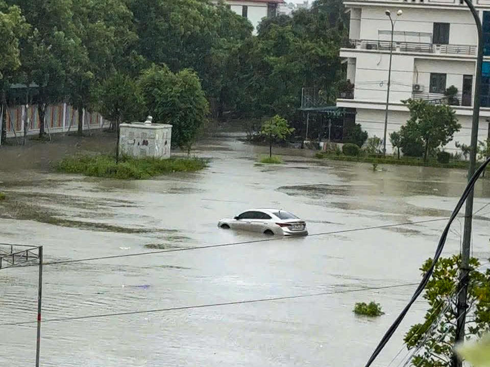 Một xe ô tô bị ngập hơn nửa bánh gần chung cư Đông Phát, phường Hạc Thành. Ảnh: Văn Tiến.