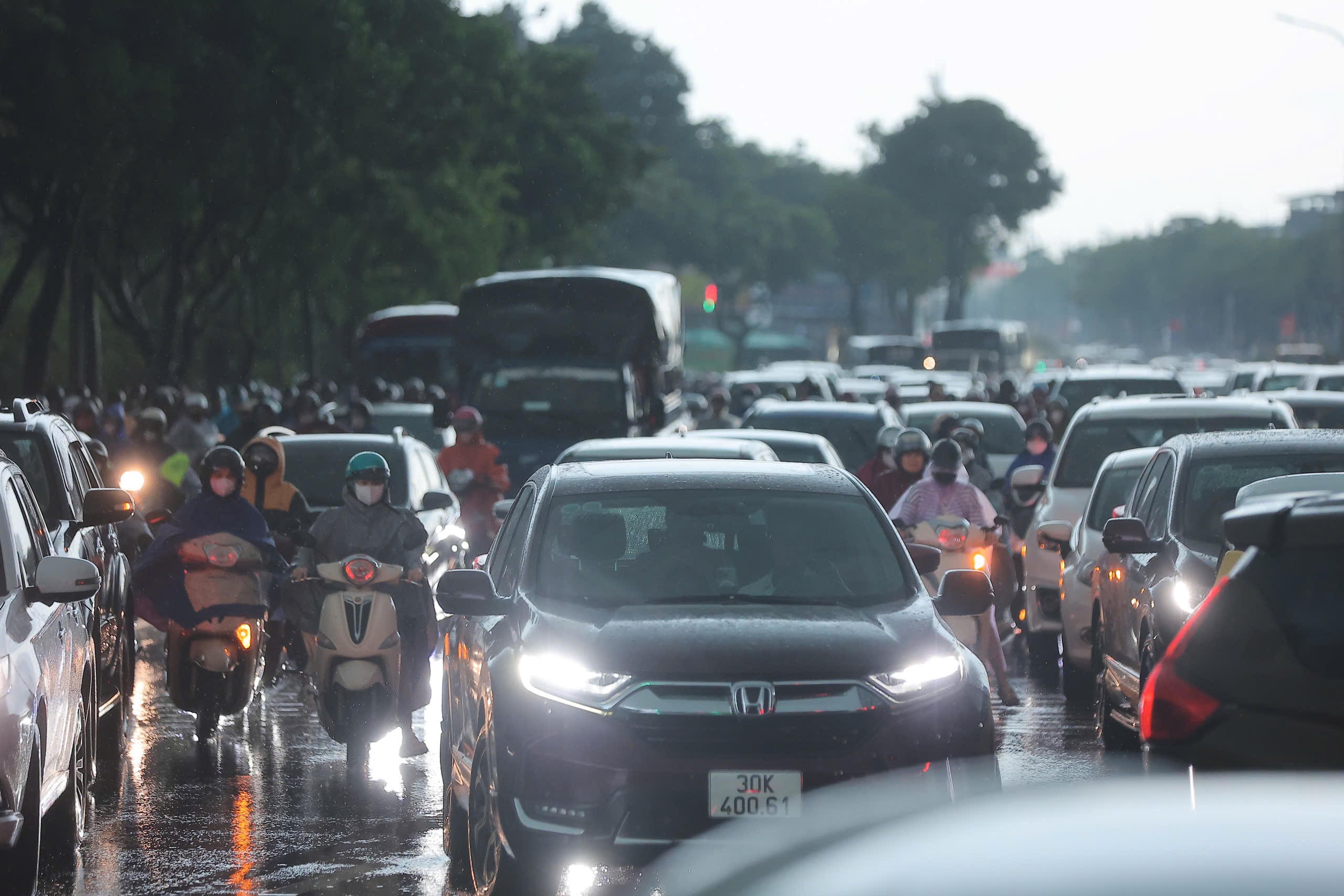 Tại tuyến đường Lê Quang Đạo dòng phương tiện nhích từng chút một di chuyển trong mưa lớn.