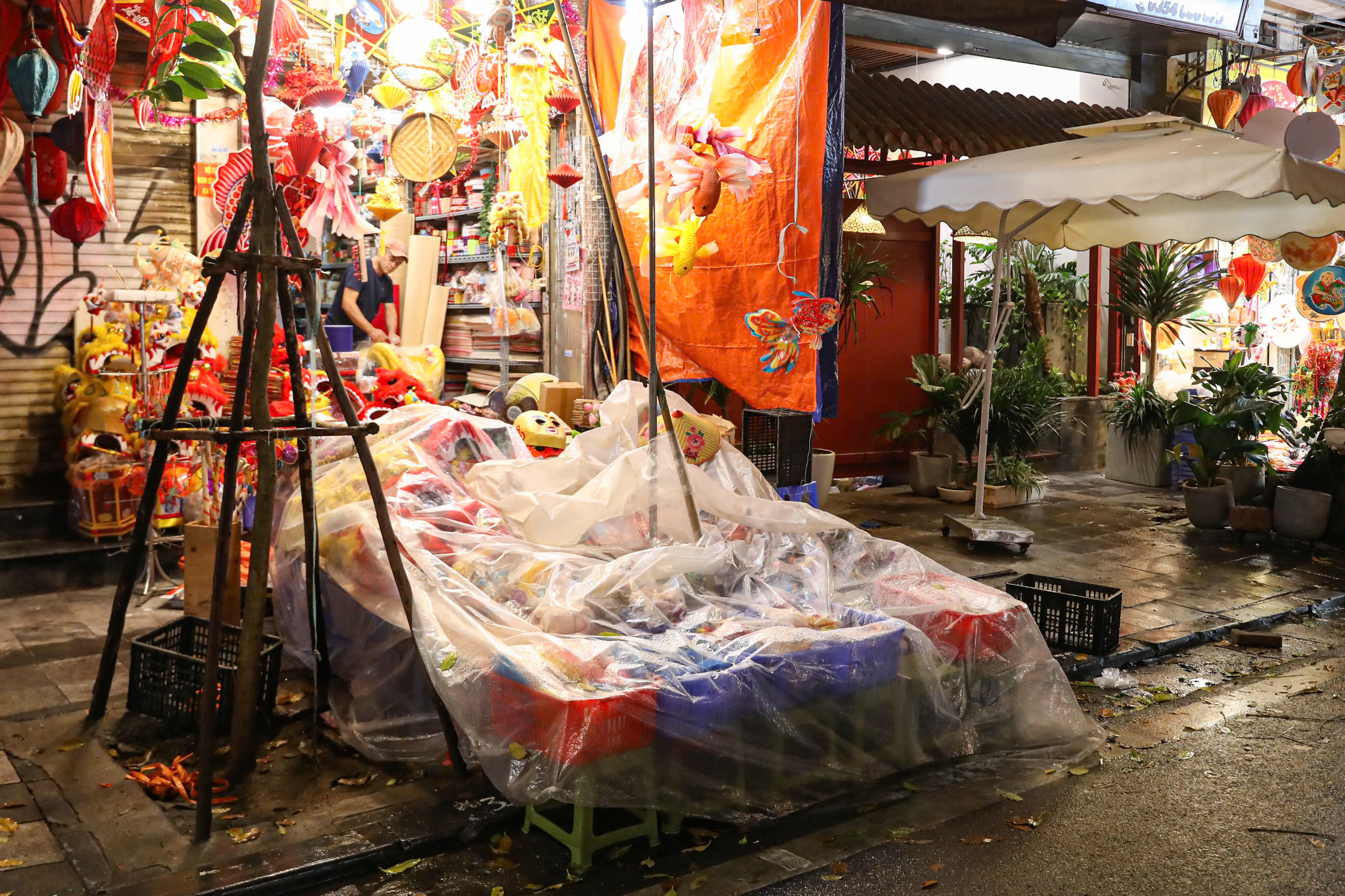 Mưa rả rích, ế ẩm khách nhiều tiểu thương phải phủ nilong để tránh bị hư hỏng đồ chơi.