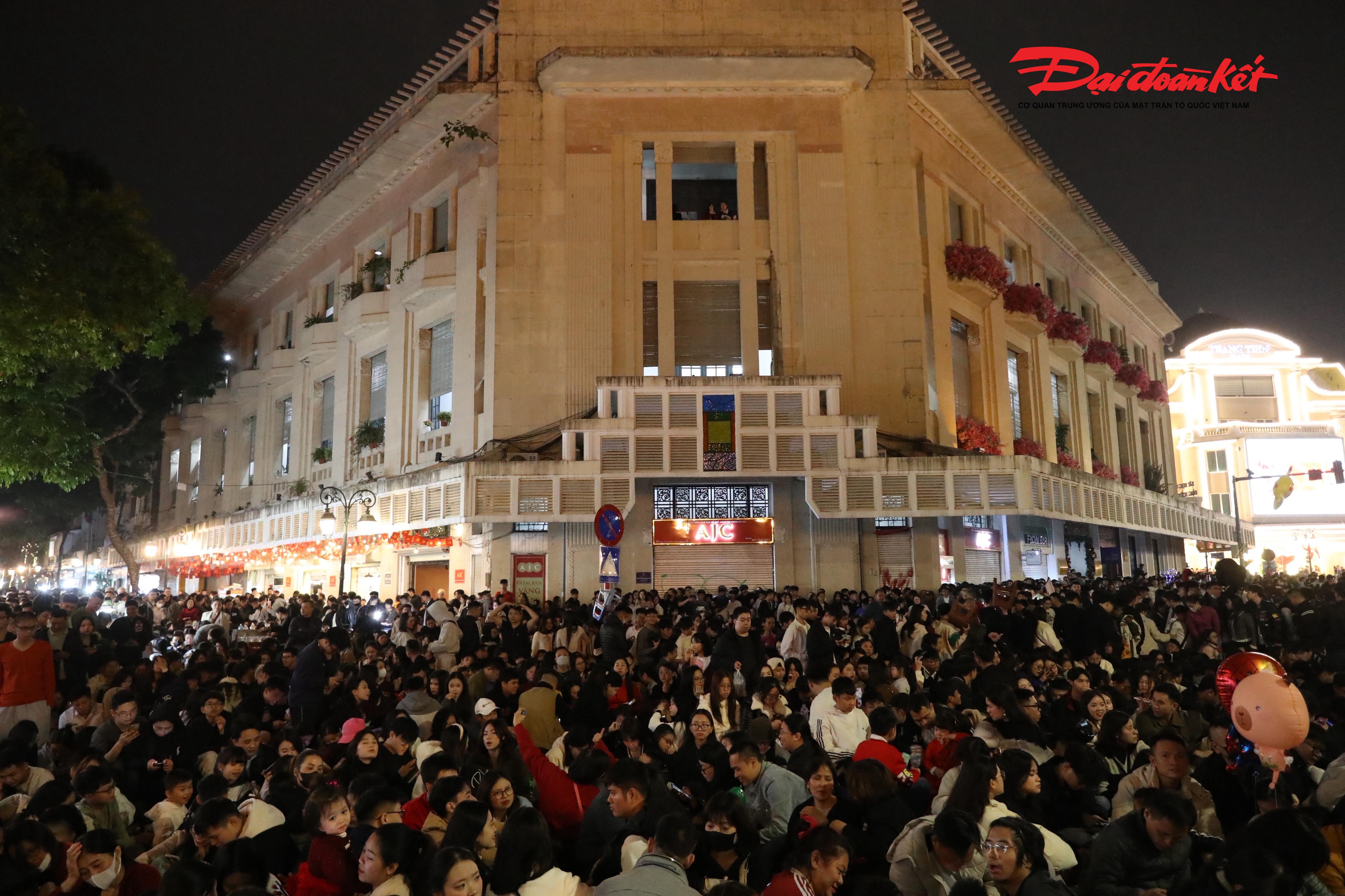 Từ tối 31/12/2025, các tuyến phố quanh hồ Gươm như Đinh Tiên Hoàng, Lê Thái Tổ, Hàng Khay, Tràng Tiền… đã ken đặc người. Nhiều gia đình, nhóm bạn trẻ, du khách nước ngoài lựa chọn đứng ở những vị trí đẹp ven hồ, quảng trường Đông Kinh Nghĩa Thục để chờ đón khoảnh khắc chuyển giao năm cũ – năm mới.