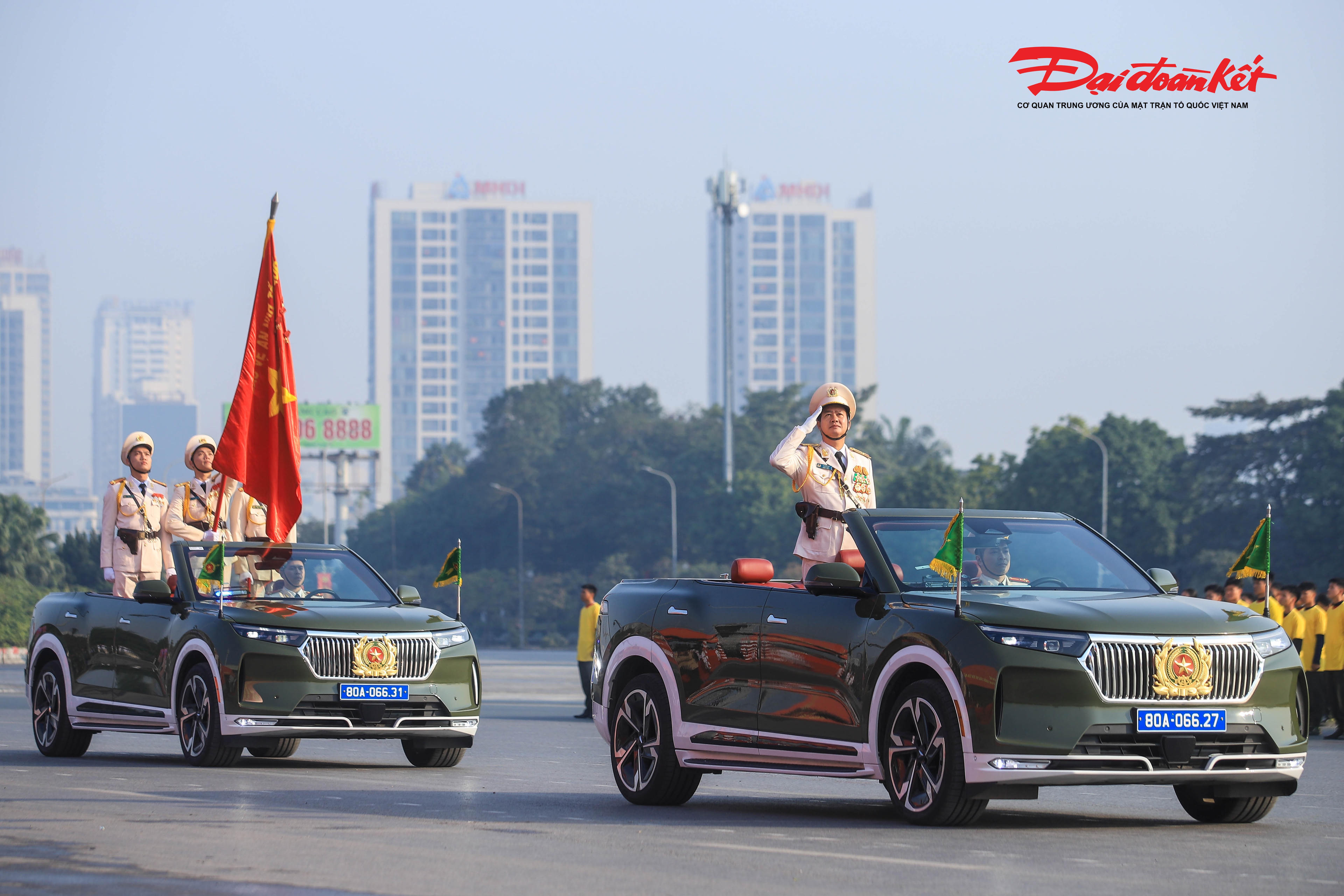 Thiếu tướng Lê Văn Sao - Phó tư lệnh Cảnh sát cơ động (Bộ Công an) - trên xe chỉ huy dẫn đầu lực lượng duyệt đội hình bên cạnh Tổ công an kỳ, mang theo lá cờ truyền thống với dòng chữ "Bảo vệ an ninh Tổ quốc".