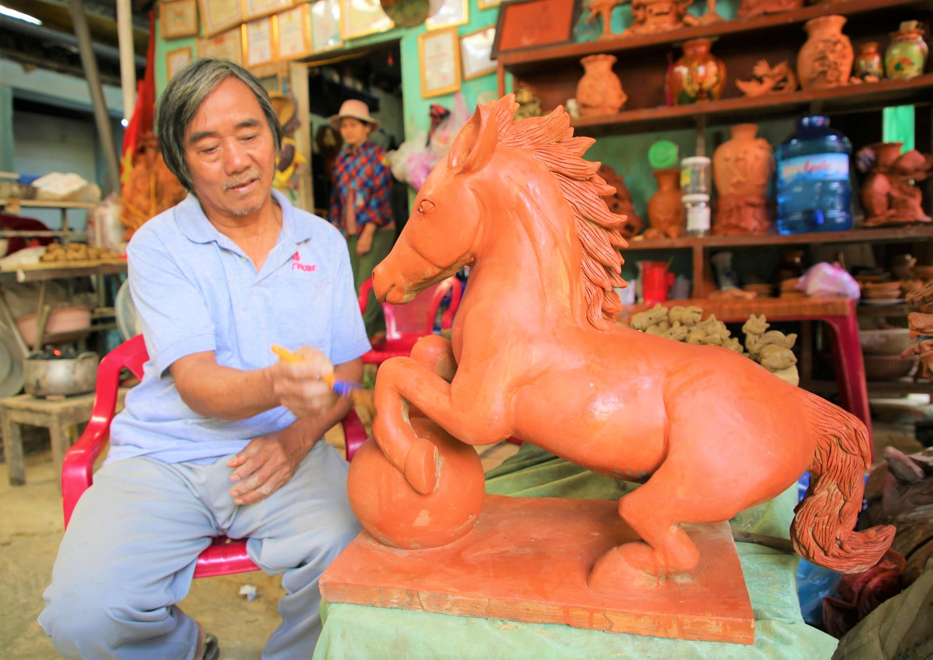 Nghệ nhân làng gốm Thanh Hà đang tỉ mỉ tạo dáng cho linh vật ngựa. Ảnh: CV.