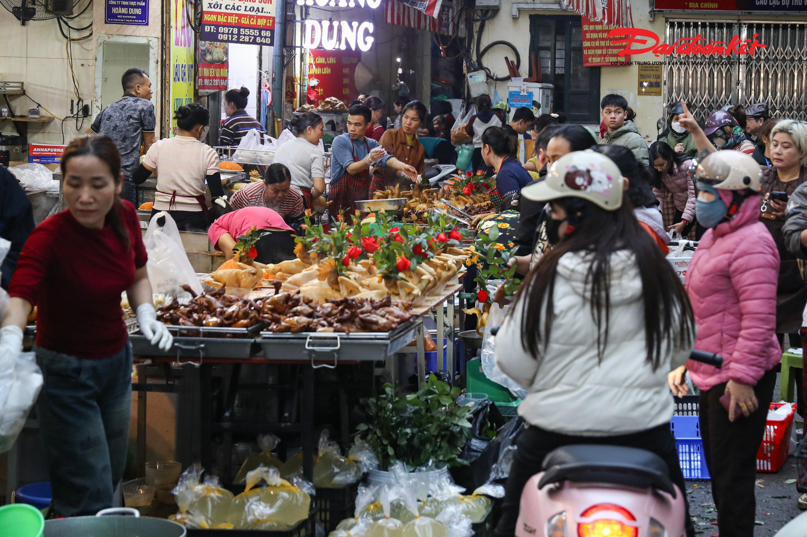 Theo ghi nhận của phóng viên Báo Đại đoàn kết, từ khoảng 5–6 giờ sáng, các cửa hàng kinh doanh đồ cúng tại khu vực Hàng Bè đã đồng loạt mở cửa, sẵn sàng phục vụ nhu cầu mua sắm của người dân. Trên những gian hàng nhỏ, các mâm lễ được bày biện tươm tất với gà luộc ngậm hoa hồng vàng óng, xôi gấc, bánh chưng xanh cùng mâm ngũ quả đầy đặn, tạo nên khung cảnh rực rỡ, thu hút ánh nhìn của người qua lại.