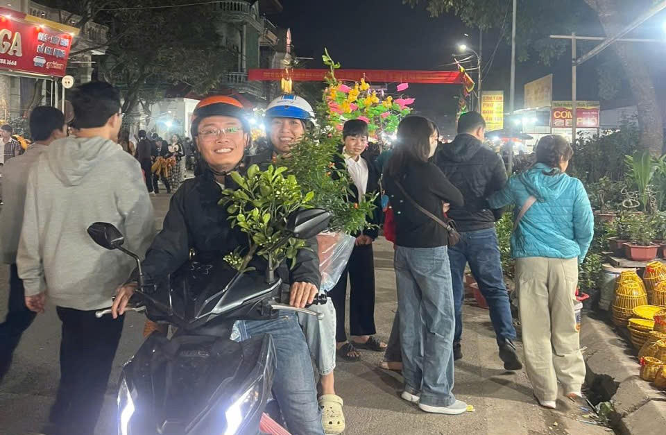 Vợ chồng anh Trần Huy Thành (phường Nam Định) vui vẻ, hạnh phúc rời chợ Viềng Phủ cùng cây bưởi giống, một số nông cụ vừa mua được. Ảnh: Duy Hưng.