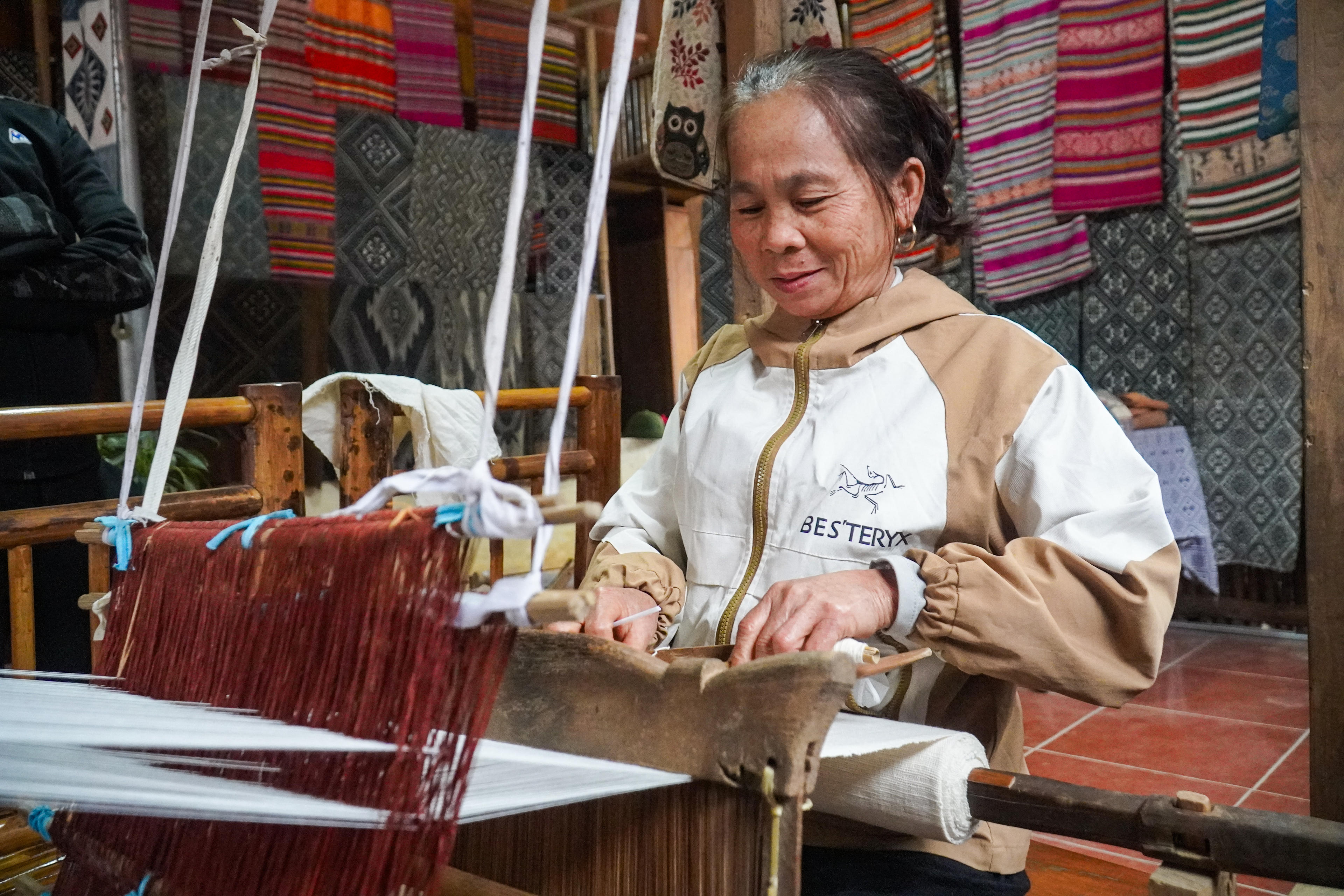 Trải qua thăng trầm, những khung cửi gỗ vẫn đều đặn vang lên trong nếp nhà sàn, nơi phụ nữ Thái gửi gắm sự khéo léo và óc thẩm mỹ qua từng sợi chỉ. Ảnh: Đình Minh.