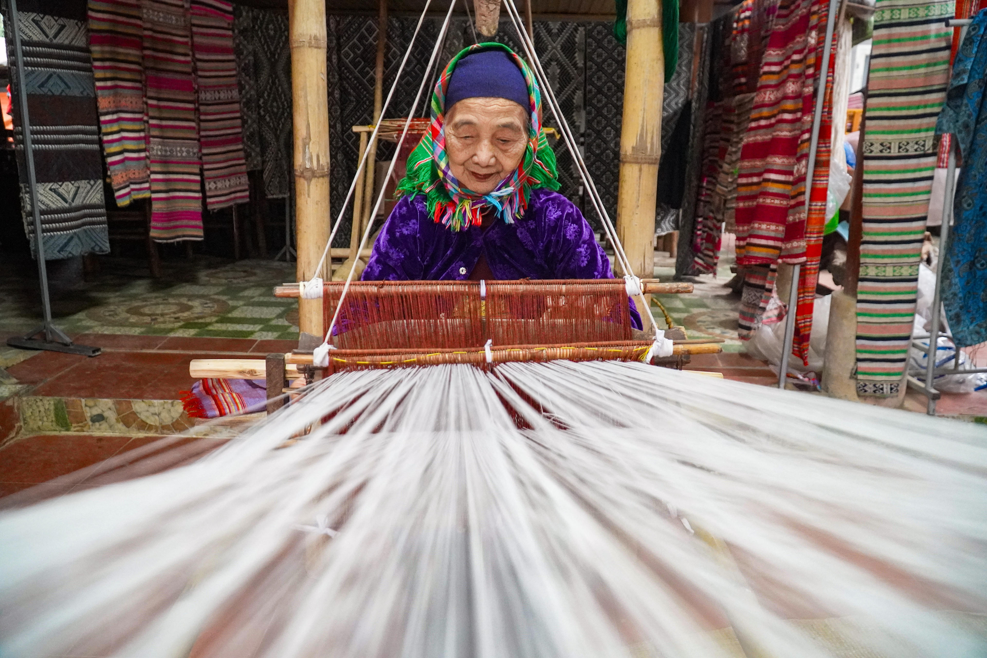 Theo bà Hà Thị Nhân (80 tuổi), từ ngày nhỏ, bà và các bé gái trong bản đã được mẹ, bà dạy cách mắc khung, đưa thoi, phối màu, coi đó như một phần tất yếu của hành trang trưởng thành. Ảnh: Đình Minh.