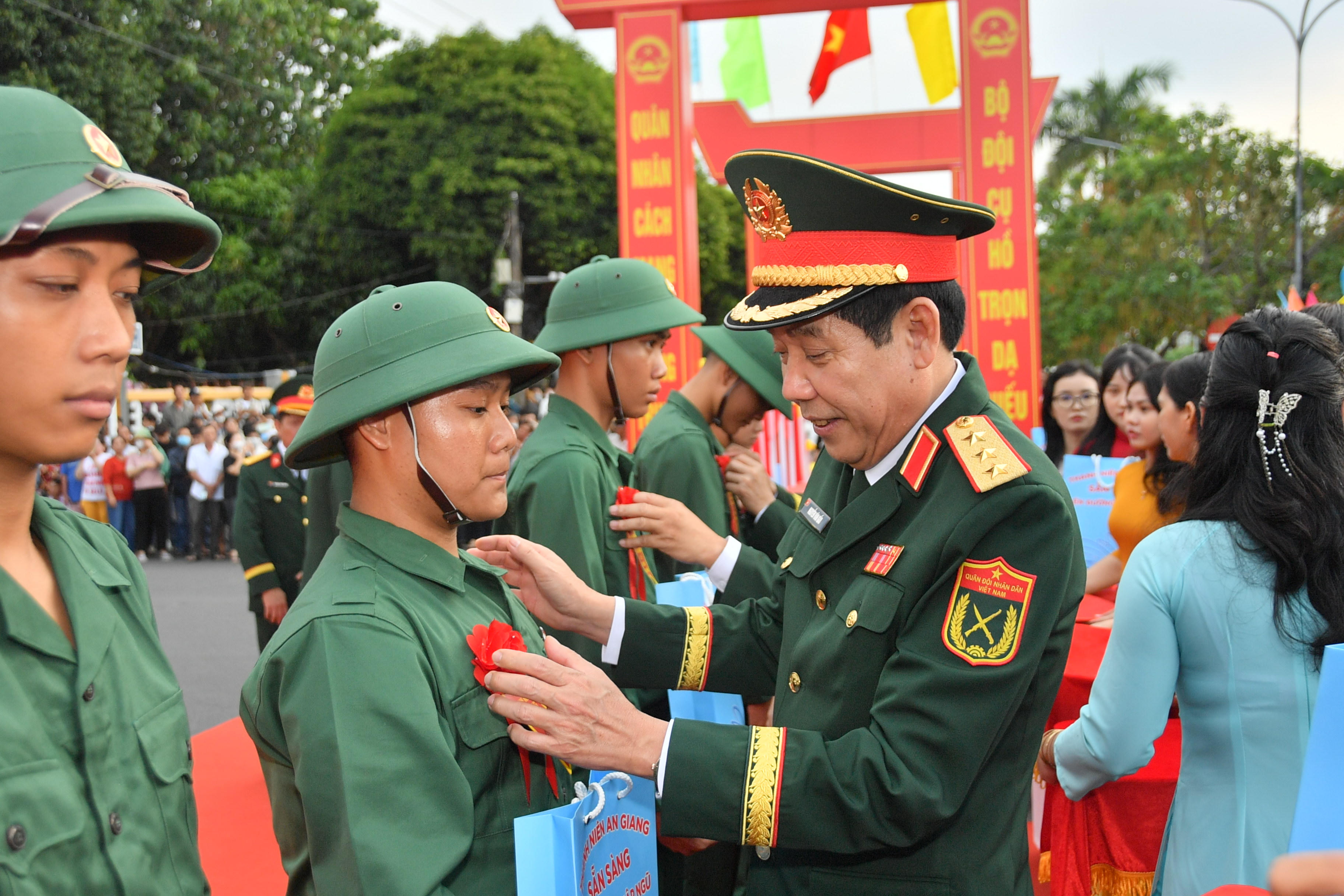 Thượng tướng Nguyễn Văn Gấu - Ủy viên Trung ương Đảng, Ủy viên Quân ủy Trung ương, Thứ trưởng Bộ Quốc phòng trao hoa chúc mừng thanh niên lên đường nhập ngũ. Ảnh: Phương Vũ.