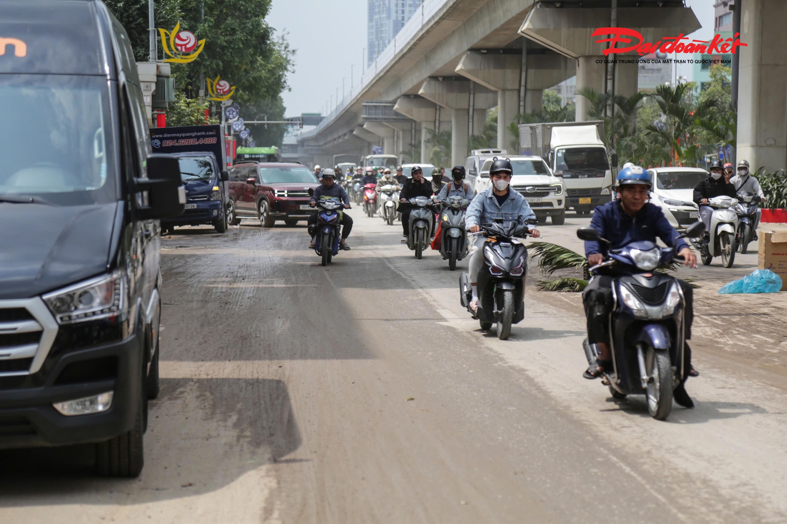 Trước số nhà 231 Quang Trung, bùn đất rải rác trên mặt đường khiến người dân phải đặt các vật cảnh báo để nhắc nhở người tham gia giao thông.