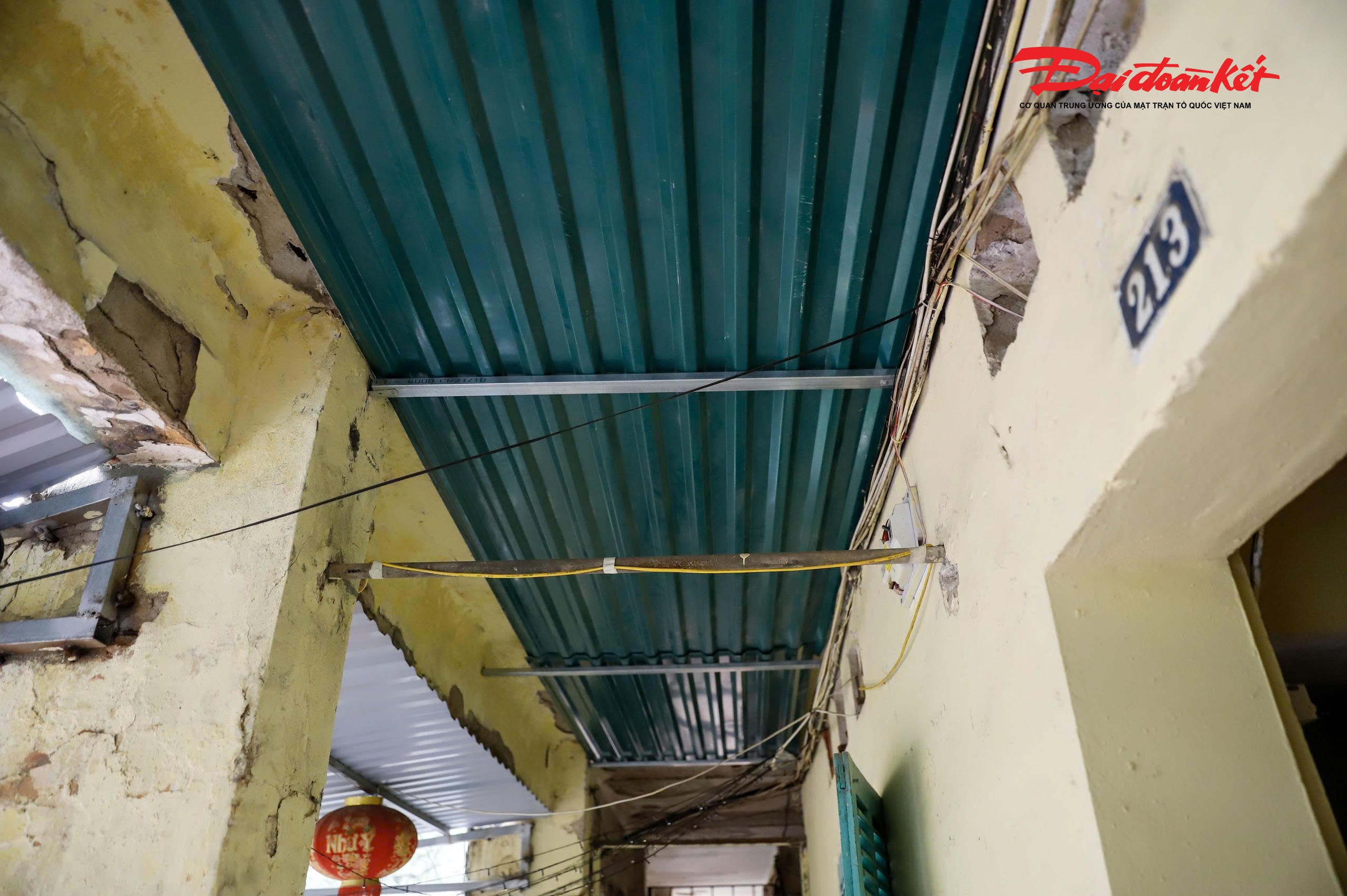 Mái nhà lợp ngói đã xuống cấp, trần khu vực hành lang nhiều vị trí bị hư hỏng, các hộ dân buộc phải tự sửa chữa, gia cố tạm bằng những tấm tôn để đảm bảo an toàn.