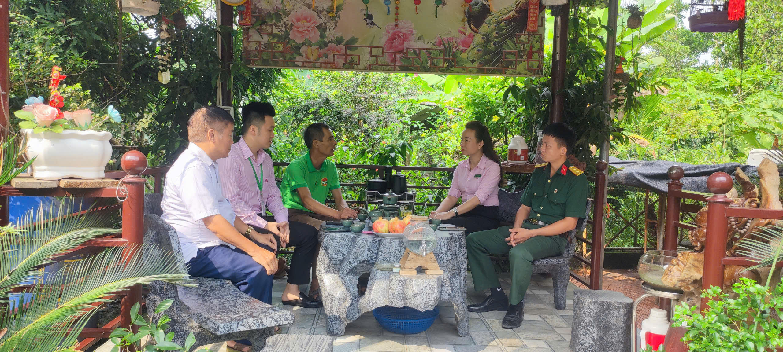 Cán bộ Phòng giao dịch Ngân hàng Chính sách xã hội Đồng Hỷ hướng dẫn ông Long cách theo dõi khoản vay online. Ảnh; L.H